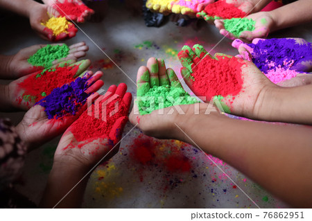 multiple colored powder on hands for holiday 76862951