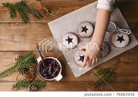 Star-shaped christmas cookies on a wooden table. Biquites with jam and powder, decor made of spruce 76863936