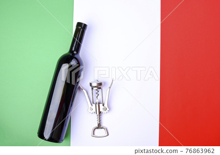 Wine bottle and corkscrew on the Italian flag. The concept of a winemaker and a traditional harvest 76863962
