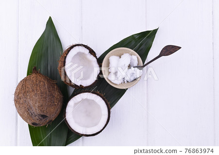 Broken coconut and butter. Exotic fruit on a white background. Free space for text. Copy space. Flat Broken coconut and butter. Exotic fruit on a white background. Free space for text. Copy space. Flat 76863974