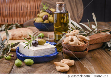 Greek cheese with olives and italian and ITALIAN CRACKERS or TARALLI . Fresh olive branches, olive 76864034