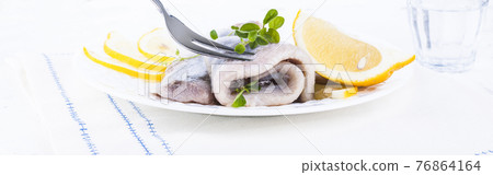 Dutch herring. Traditional Dutch food, marinated fish fillet with onion and lemon. Food high in 76864164