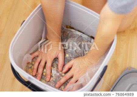 Blurred compost making process: Pushing from above to remove air Blurred compost making process: Pushing from above to remove air 76864989