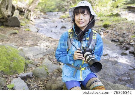 Trekking image of a woman taking pictures in the mountains Trekking image of a woman taking pictures in the mountains 76866542