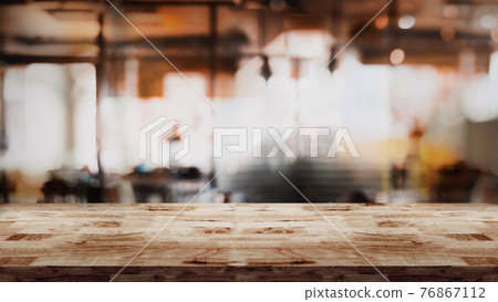 Empty wood table with blur cafe or coffee shop background. Empty wood table with blur cafe or coffee shop background. 76867112