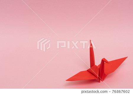 Red paper cranes on a pink background Red paper cranes on a pink background 76867602