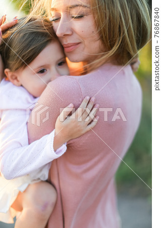 Portrait of european mother hugging little daughter and smiling. Portrait of european mother hugging little daughter and smiling. 76867840