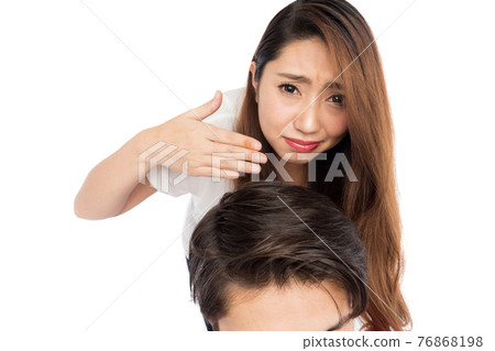 A woman sniffing a man's scalp 76868198