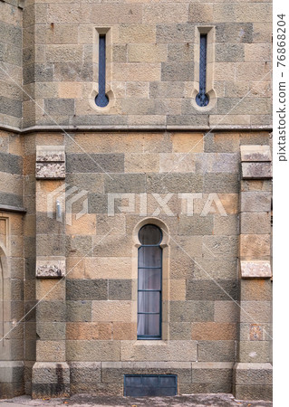 Stone wall and narrow window of the ancient castle. 76868204