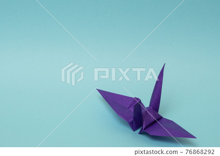 Purple paper crane on a light blue background 76868292