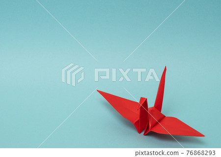 Red paper crane on a light blue background Red paper crane on a light blue background 76868293