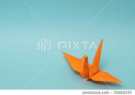 Orange paper cranes on a light blue background Orange paper cranes on a light blue background 76868295