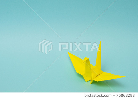 Yellow paper crane on a light blue background 76868298