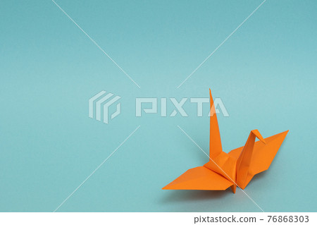 Orange paper cranes on a light blue background Orange paper cranes on a light blue background 76868303