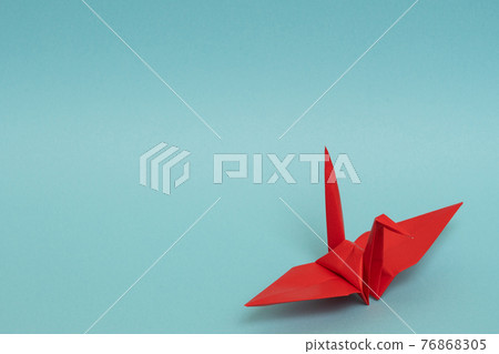 Red paper crane on a light blue background Red paper crane on a light blue background 76868305