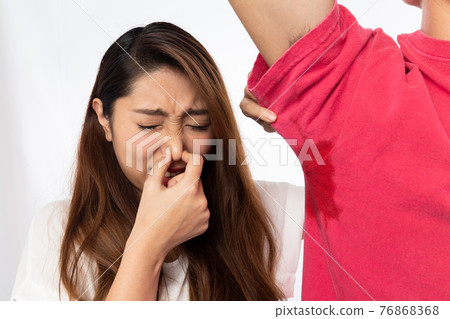A woman pinching her nose to sweat on the side of a man A woman pinching her nose to sweat on the side of a man 76868368