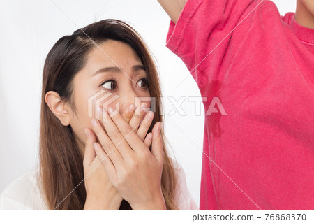 A woman who closes her mouth with sweat from the side of a man A woman who closes her mouth with sweat from the side of a man 76868370