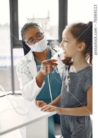 Doctor makes a procedure for a little girl 76869113