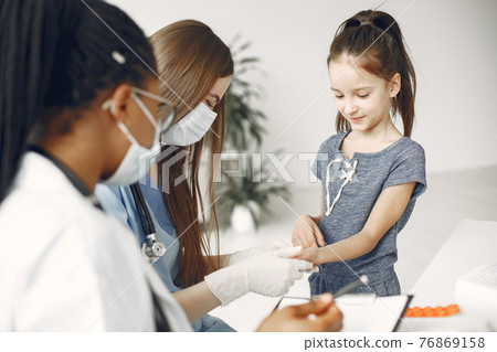Doctor examines a little girl in hospital 76869158