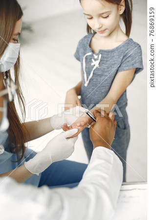 Doctor examines a little girl in hospital Doctor examines a little girl in hospital 76869159