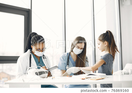 Doctor examines a little girl in hospital 76869160