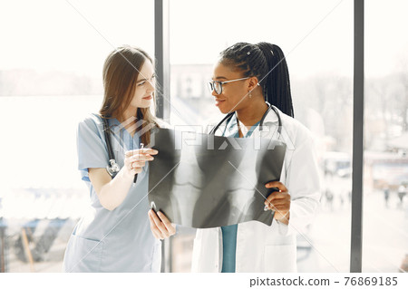 Two female doctors looking at an x-ray Two female doctors looking at an x-ray 76869185