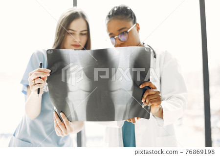 Two female doctors looking at an x-ray Two female doctors looking at an x-ray 76869198