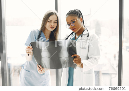 Two female doctors looking at an x-ray Two female doctors looking at an x-ray 76869201