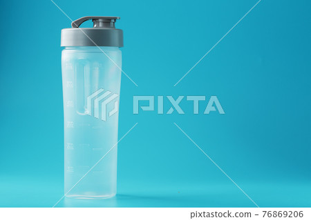 Shaker is an empty plastic smoothie cup on a blue background. Shaker is an empty plastic smoothie cup on a blue background. 76869206
