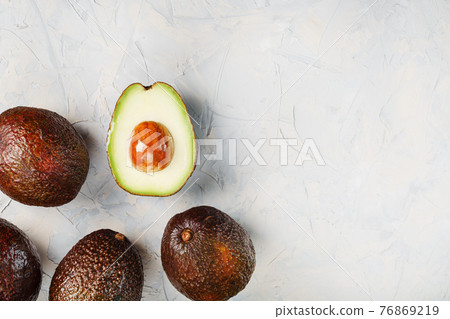 Sliced and whole organic Hass avocado on a gray background. 76869219