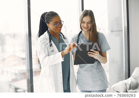 Two female doctors looking at an document Two female doctors looking at an document 76869263