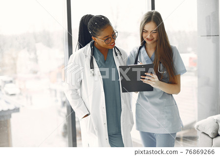 Two female doctors looking at an document Two female doctors looking at an document 76869266