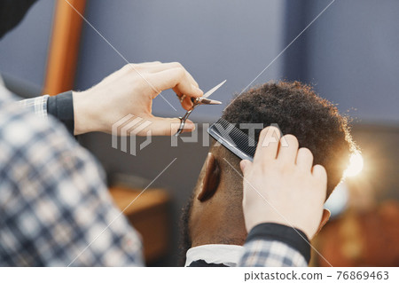 Young African-american man visiting barbershop Young African-american man visiting barbershop 76869463