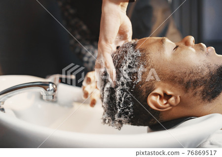 Young African-american man visiting barbershop 76869517