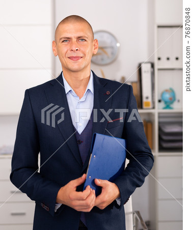 Portrait of positive business man with folder of documents 76870848