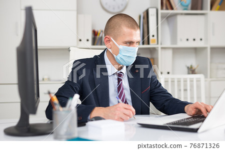 Young man entrepreneur in protective face mask 76871326