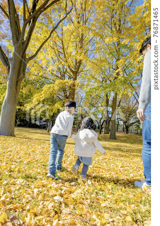 父親看著他的兄弟姐妹在秋葉公園玩耍 76871465
