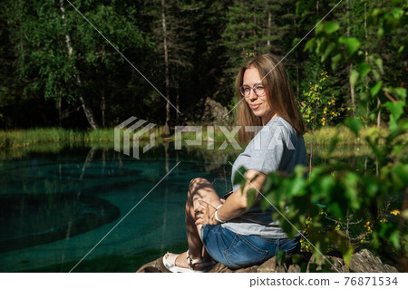 Woman resting at mountain lake in summer 76871534