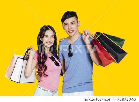 Happy young couple holding the shopping bags Happy young couple holding the shopping bags 76872040