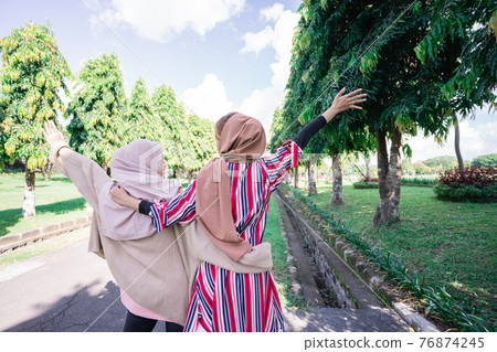 Two friends muslim enjoying the summer sun Two friends muslim enjoying the summer sun 76874245