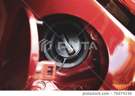 Fuel tank door is open and fuel tank cap closed of the red car Fuel tank door is open and fuel tank cap closed of the red car 76874336