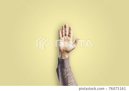 Man arm gesturing with open hand isolated on yellow background Man arm gesturing with open hand isolated on yellow background 76875161
