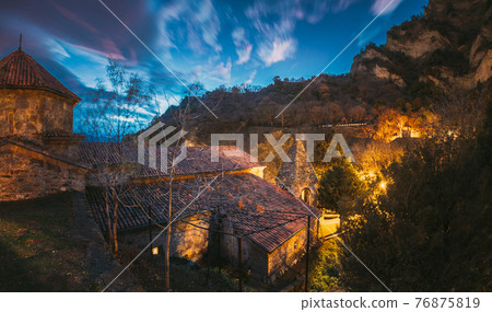 Mtskheta, Georgia. Shio-mgvime Monastery. Church Of Holy Virgin Or Theotokos In Medieval Monastic Shiomgvime Complex In Limestone Canyon Under Autumn Night Cloudy Starry Sky. Panorama Mtskheta, Georgia. Shio-mgvime Monastery. Church Of Holy Virgin Or Theotokos In Medieval Monastic Shiomgvime Complex In Limestone Canyon Under Autumn Night Cloudy Starry Sky. Panorama 76875819
