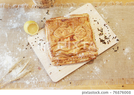Pie, lime and pepper on a chopping board. The food is ready to eat. Puff Pastry pastry Pie, lime and pepper on a chopping board. The food is ready to eat. Puff Pastry pastry 76876008