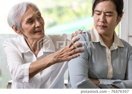 Asian senior grandmother reconcile touchy her granddaughter,angry upset woman with crossed arms,old elderly trying to reconcile by shoulder squeeze after conflict,misunderstanding,family life problems 76876307
