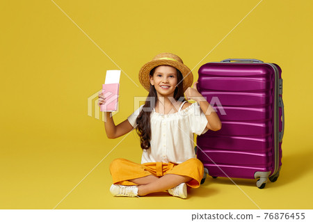 little girl with suitcase and passport sitting on floor 76876455