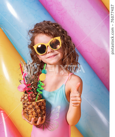 Pretty smiling girl wearing pink and blue swimwear and sunglasse 76877487