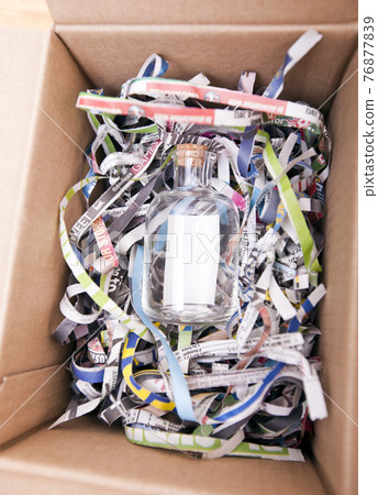Glass bottle wrapped in a box Glass bottle wrapped in a box 76877839