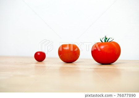 Studio Shot of three cherry tomatoes in a row 76877890