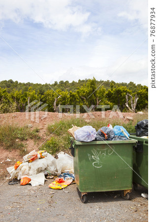 Overflowing bins next to Orange Orchard, Valencia region, Spain Overflowing bins next to Orange Orchard, Valencia region, Spain 76877934